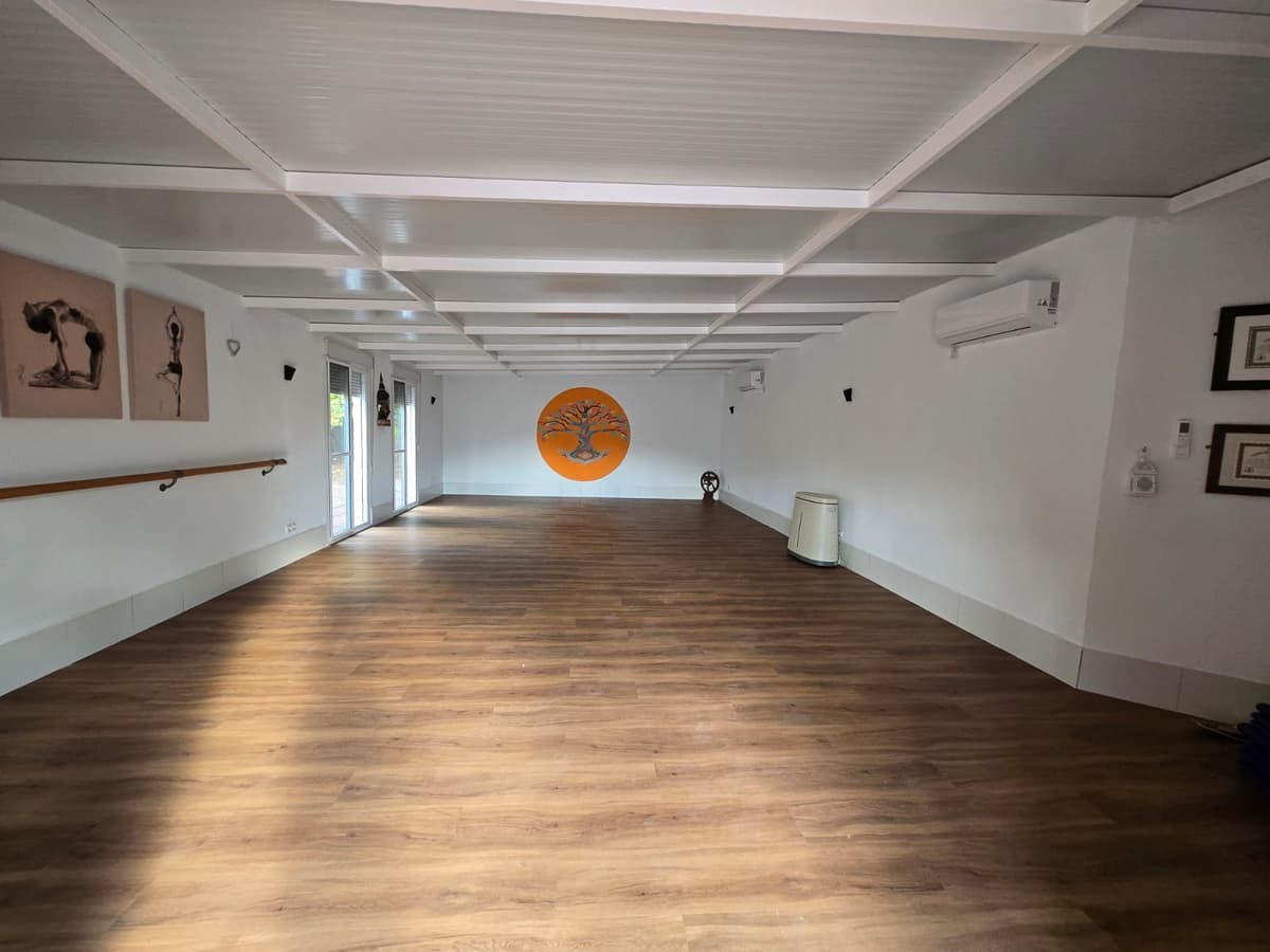 Indoor studio space with wooden floors and tree of life mural