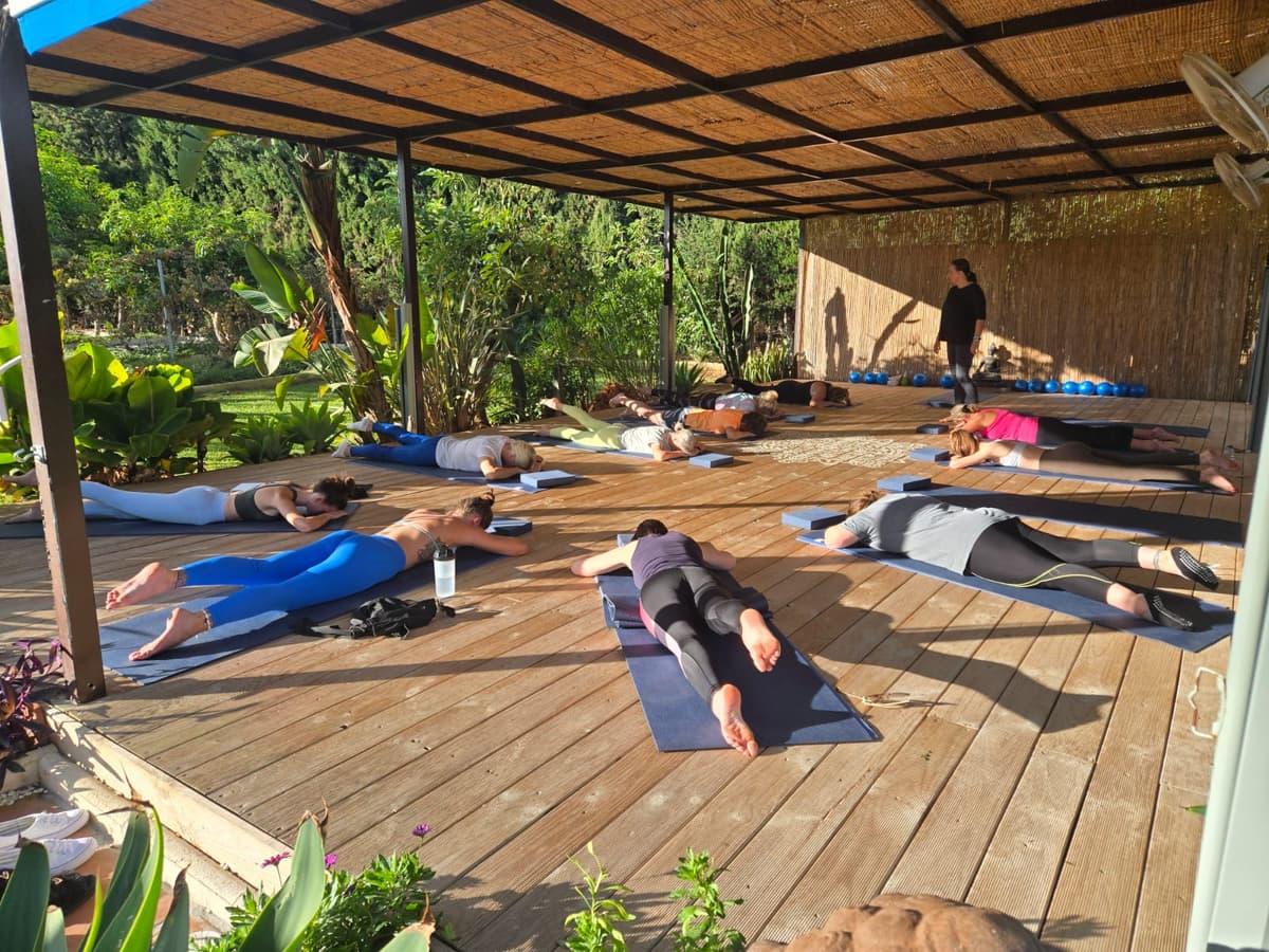 Group relaxation on mats during an outdoor Pilates session